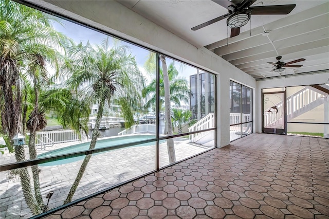 unfurnished sunroom featuring ceiling fan