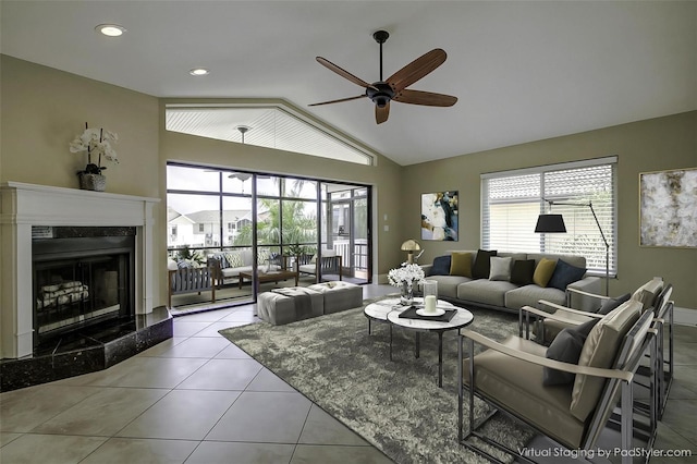 tiled living room featuring a fireplace, lofted ceiling, and ceiling fan