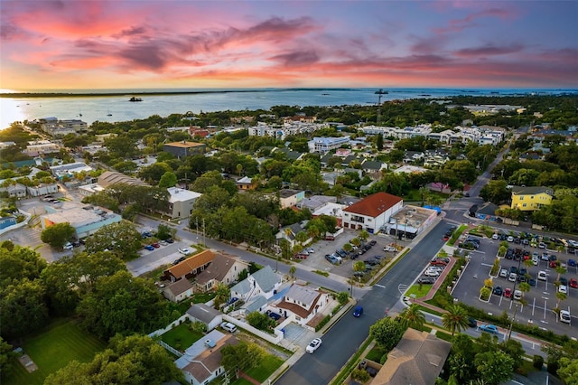 aerial view at dusk featuring a water view