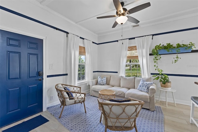 living room featuring ceiling fan, light wood-type flooring, and ornamental molding