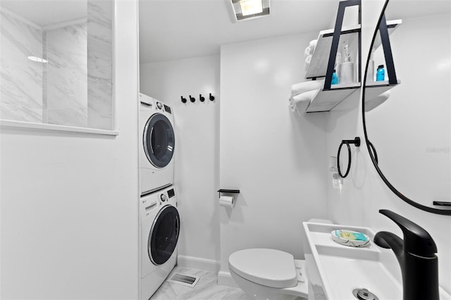 clothes washing area featuring sink, stacked washing maching and dryer, and light tile patterned floors