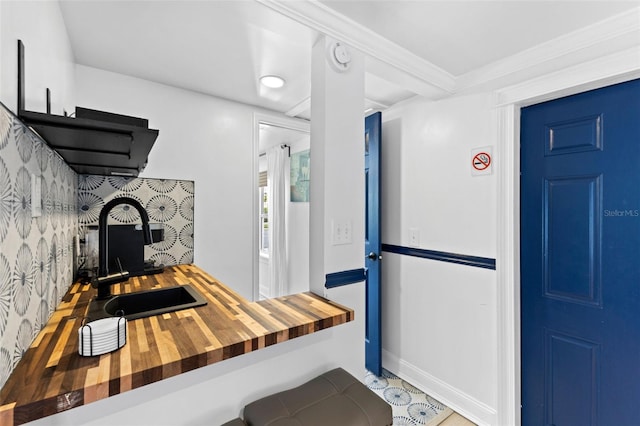 kitchen with sink, crown molding, and wood counters