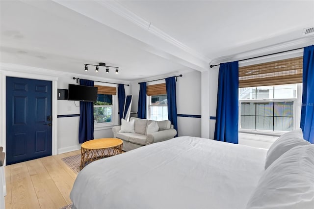 bedroom with hardwood / wood-style floors and rail lighting