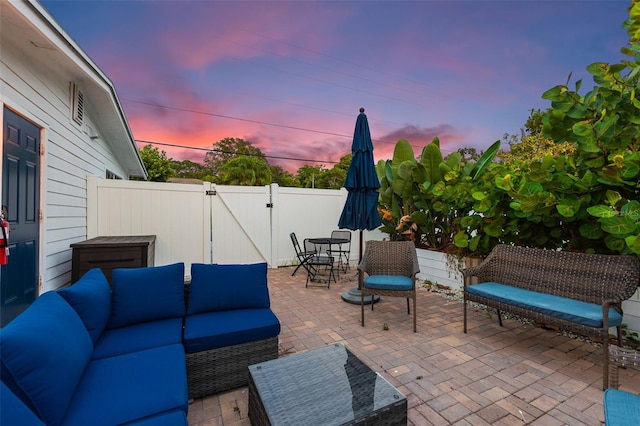 patio terrace at dusk featuring an outdoor living space