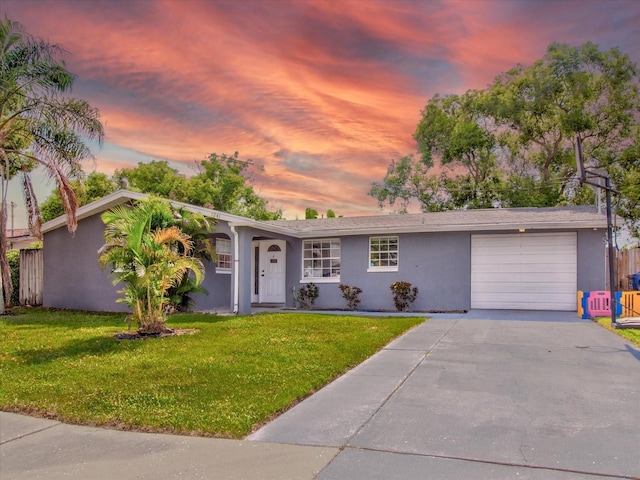 ranch-style home featuring a garage and a yard