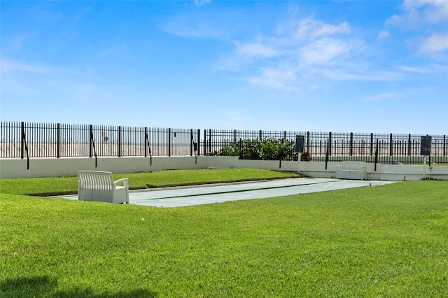 view of property's community featuring fence and a lawn