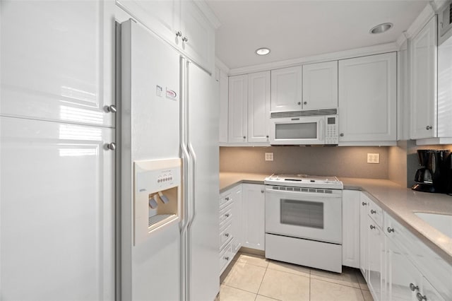 kitchen featuring white appliances, white cabinets, light tile patterned flooring, light countertops, and recessed lighting