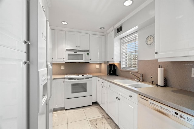 kitchen featuring light countertops, white appliances, a sink, and white cabinetry