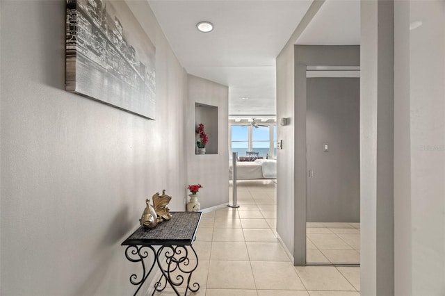 hallway with baseboards and light tile patterned flooring