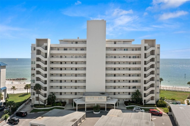 view of building exterior with a beach view and a water view