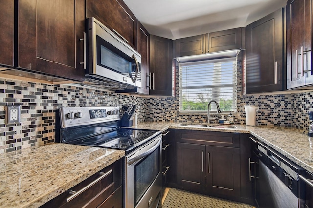 kitchen with appliances with stainless steel finishes, dark brown cabinets, sink, and decorative backsplash