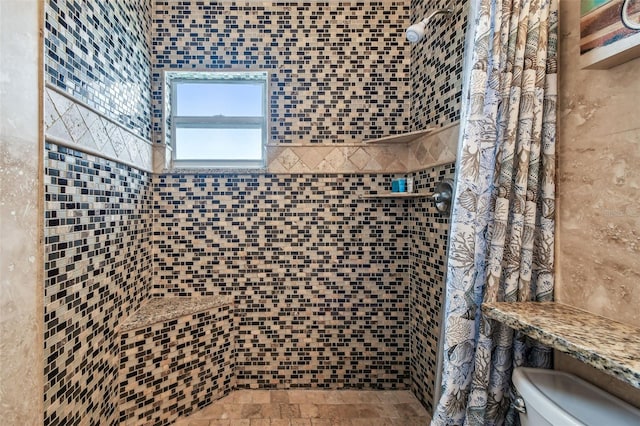 bathroom featuring toilet and tiled shower