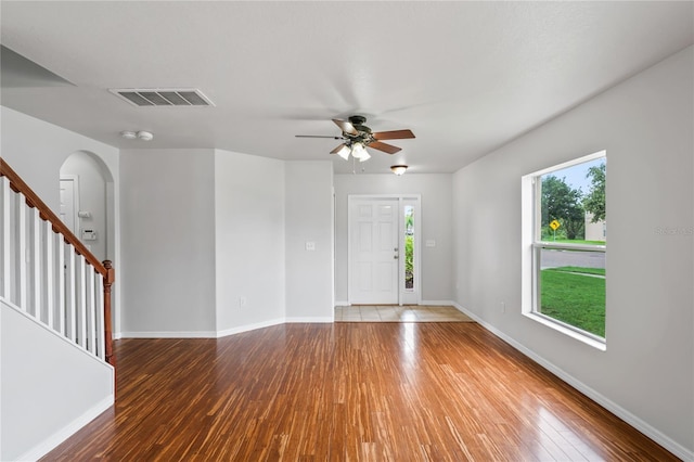 empty room featuring hardwood / wood-style flooring, a healthy amount of sunlight, and ceiling fan