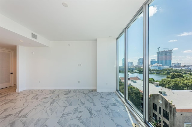 empty room featuring floor to ceiling windows and a water view