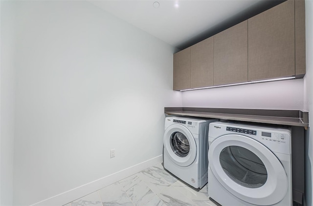 clothes washing area featuring cabinets and independent washer and dryer