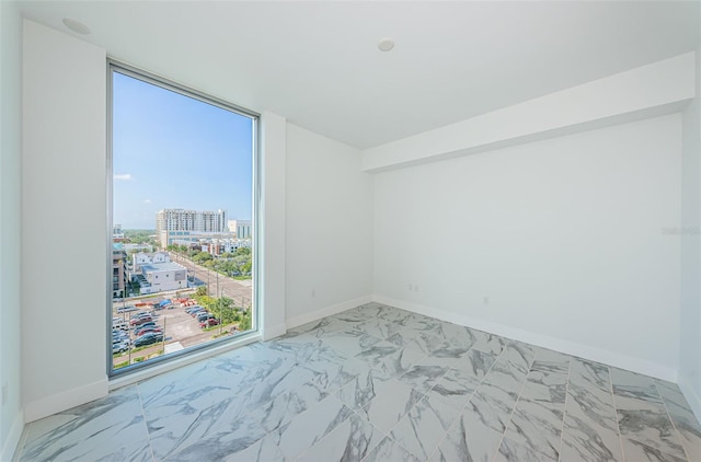 spare room with expansive windows and a healthy amount of sunlight