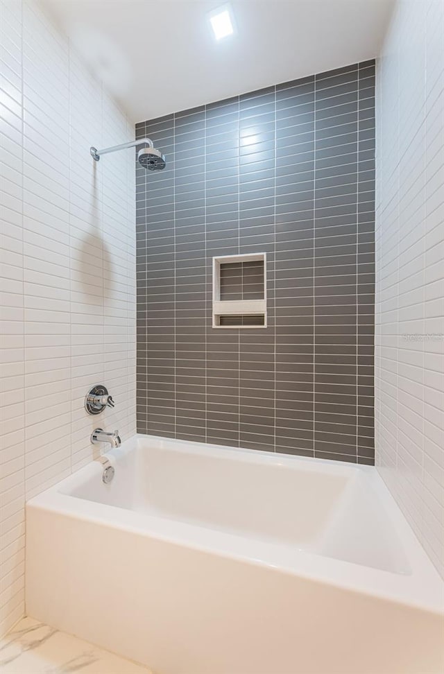 bathroom with tiled shower / bath combo