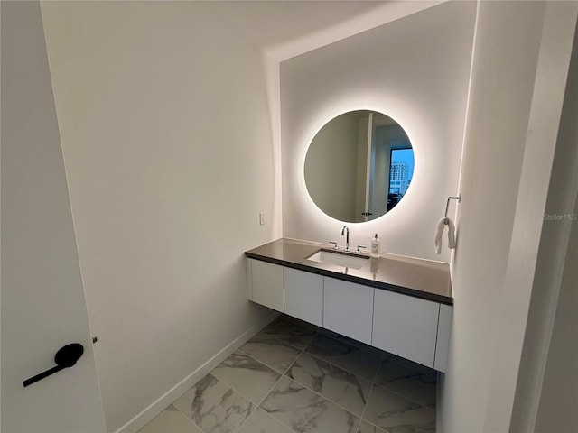 bathroom featuring marble finish floor, vanity, and baseboards