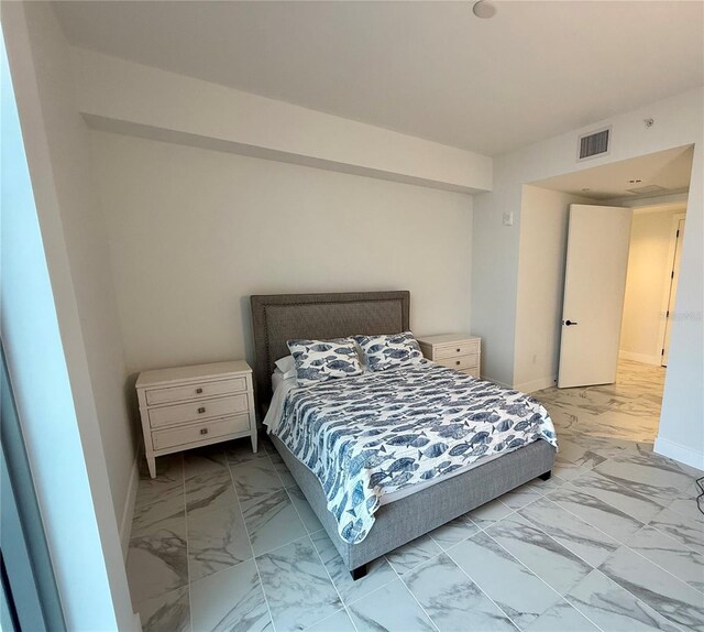 bedroom with marble finish floor, visible vents, and baseboards