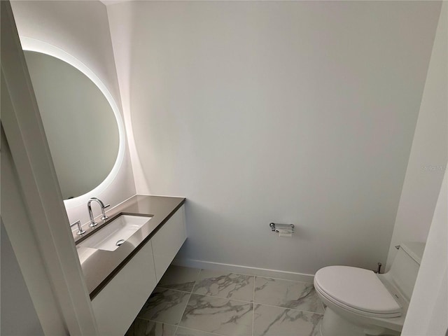 bathroom featuring marble finish floor, vanity, toilet, and baseboards