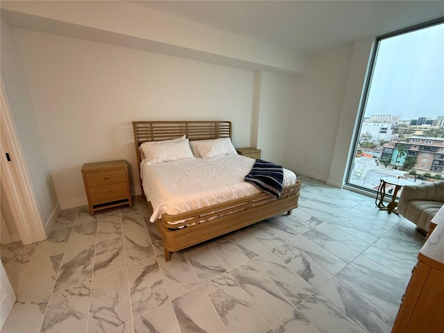 bedroom featuring marble finish floor, access to outside, and baseboards