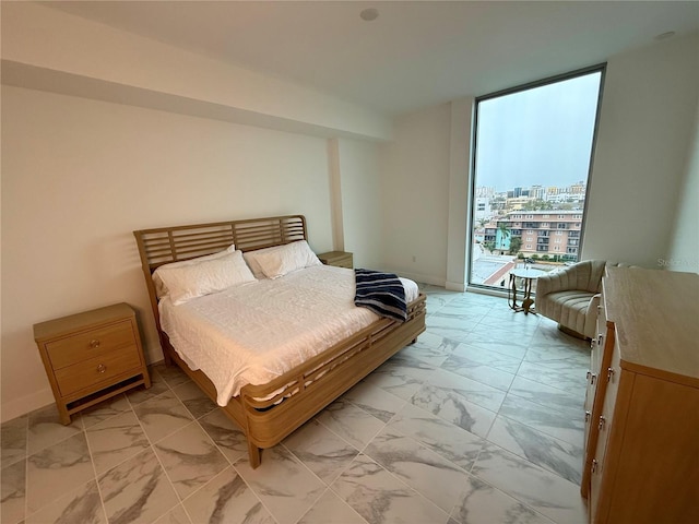 bedroom with baseboards, marble finish floor, access to outside, a view of city, and floor to ceiling windows