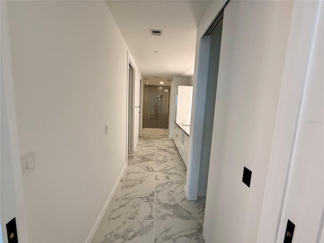 hall featuring marble finish floor, visible vents, and baseboards