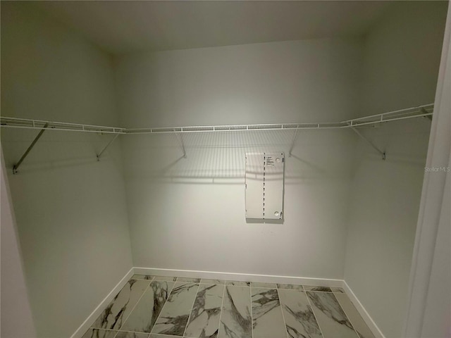 walk in closet featuring marble finish floor