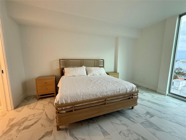 bedroom featuring marble finish floor, access to outside, and baseboards