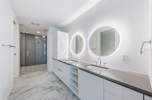 bathroom featuring double vanity, marble finish floor, a sink, and a stall shower