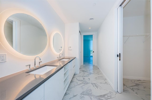 bathroom with marble finish floor, a sink, and baseboards