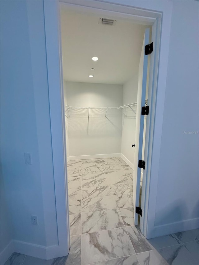 spacious closet with marble finish floor and visible vents