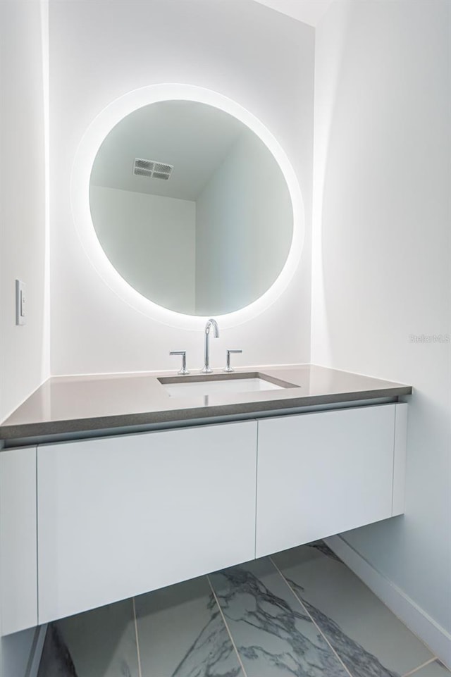 bathroom with marble finish floor, visible vents, and vanity