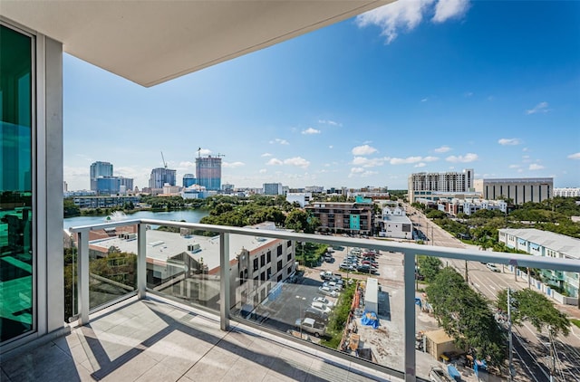 balcony with a water view and a view of city