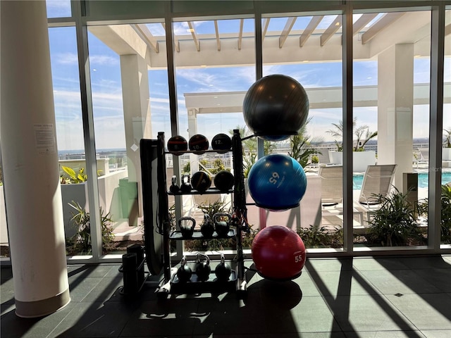 workout area with expansive windows and a water view