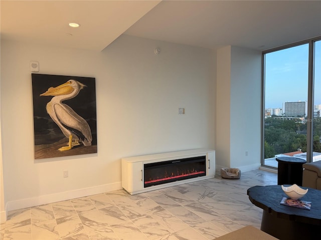 777 3rd Ave N Unit 908, Saint Petersburg, FL 33701 - living room with floor to ceiling windows, a glass covered fireplace, marble look tile flooring, and baseboards