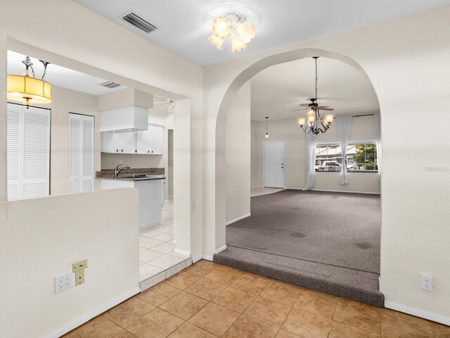 hallway featuring a chandelier, sink, and light tile patterned floors