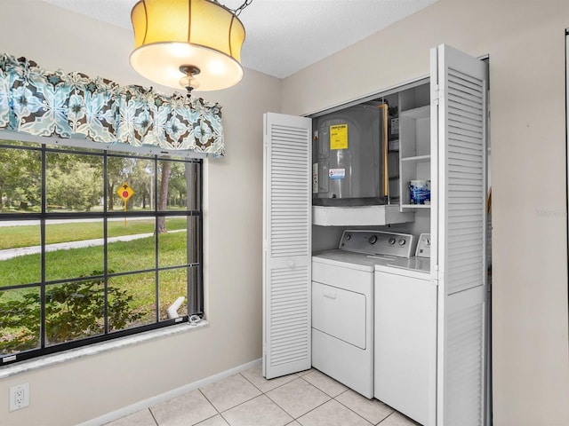 laundry room featuring laundry area, light tile patterned floors, baseboards, washer and dryer, and a textured ceiling