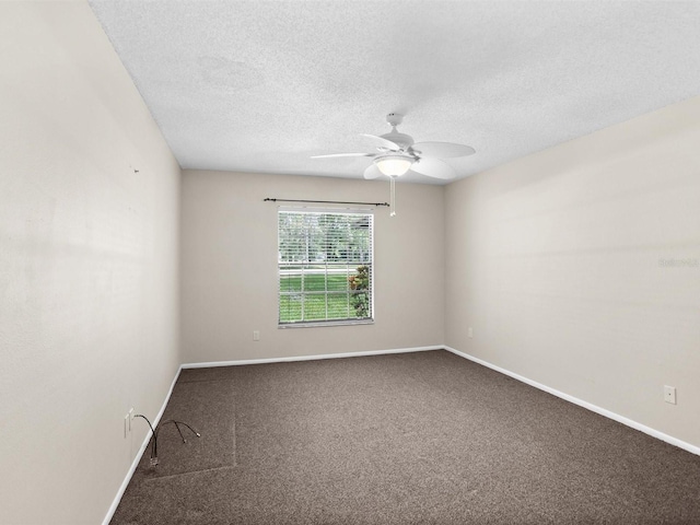 carpeted spare room featuring a textured ceiling, ceiling fan, and baseboards