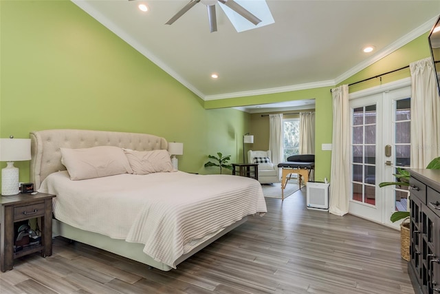 bedroom featuring ceiling fan, crown molding, hardwood / wood-style flooring, and lofted ceiling with skylight