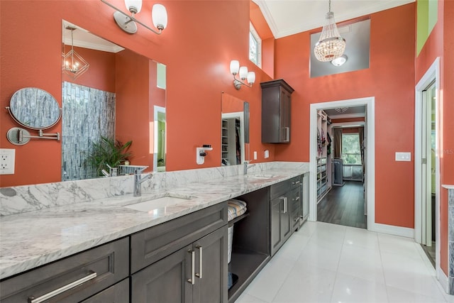 kitchen with ornamental molding, dark brown cabinetry, light stone countertops, light hardwood / wood-style floors, and pendant lighting