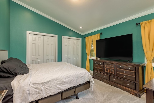 carpeted bedroom with multiple closets, vaulted ceiling, and ornamental molding