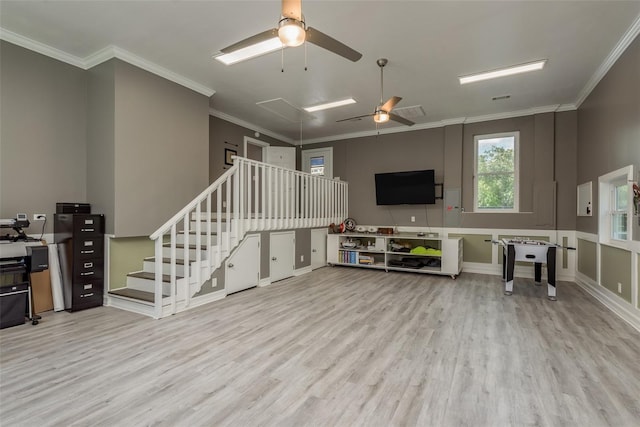 living room with ceiling fan, crown molding, and light wood-type flooring