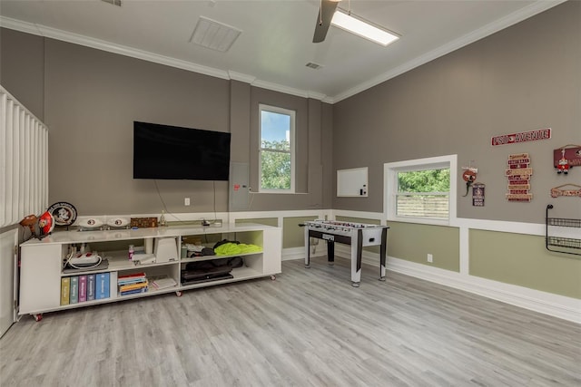 game room featuring light wood-type flooring, crown molding, plenty of natural light, and ceiling fan