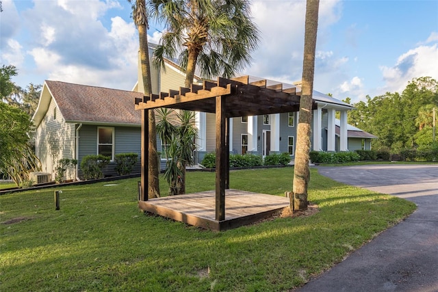 view of front of house with a pergola and a front lawn