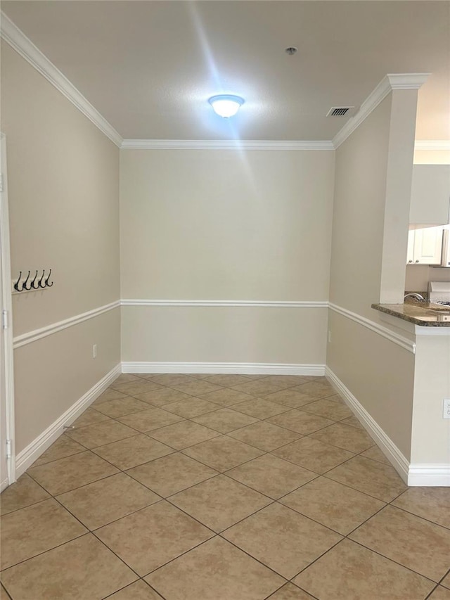 empty room with ornamental molding and light tile patterned floors