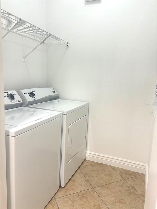 washroom with washer and dryer and light tile patterned floors