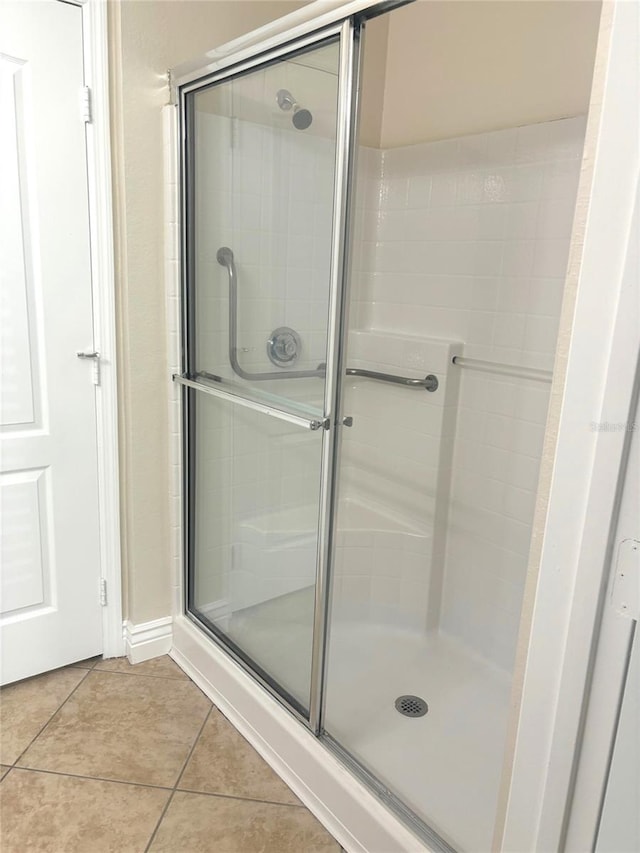 bathroom featuring an enclosed shower and tile patterned flooring