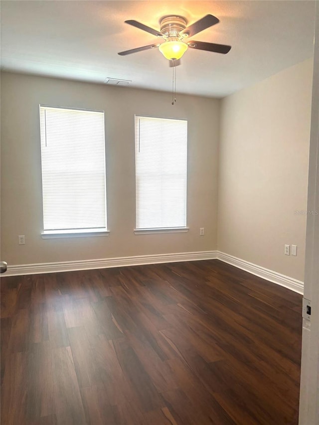 empty room featuring dark wood-type flooring and ceiling fan