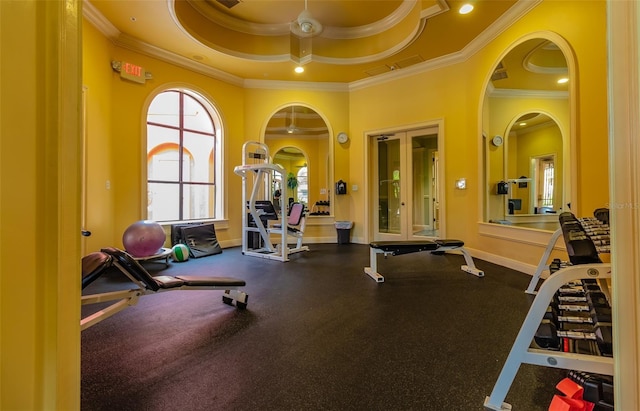 gym featuring crown molding and a tray ceiling